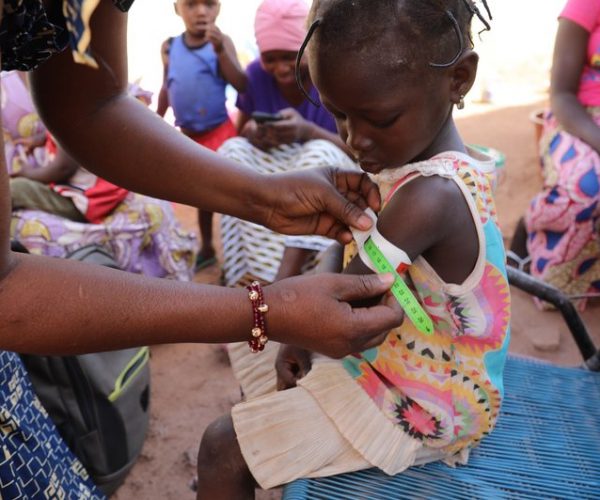 Nana Kadidia Diawara, a nurse who is a community health worker in Mali's capital city of Bamako, measures the arm of a child to check for signs of malnutrition. There's no charge for the care she provides.